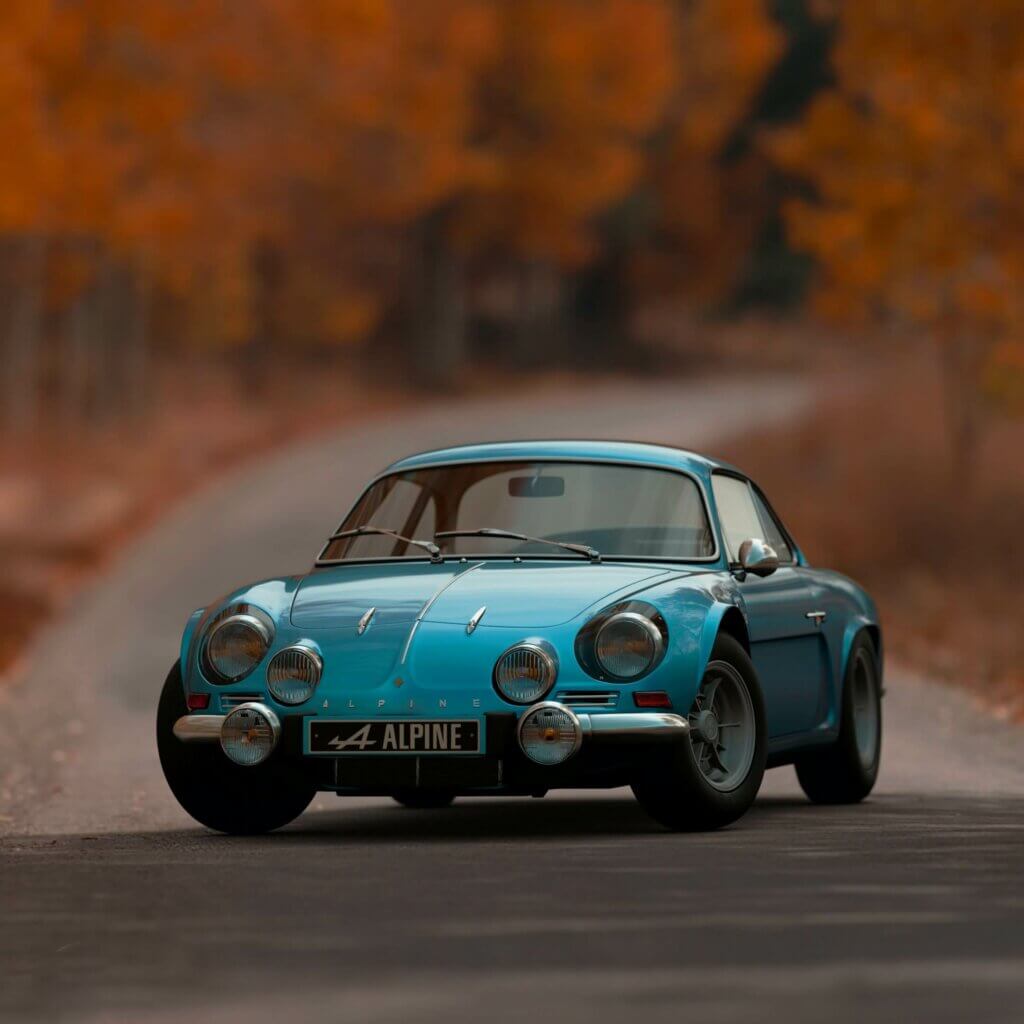 A blue Alpine classic car in the middle of a road. 